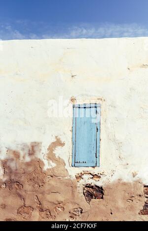 Closed window in rustic wall of old house Stock Photo