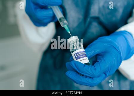 Nurse filling syringe with vaccine liquid