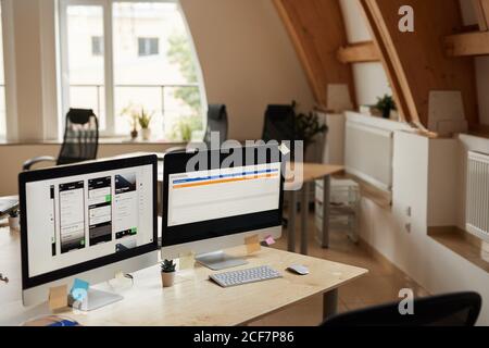 Image of computer monitors with software on the table at modern office Stock Photo