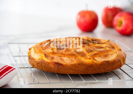 Freshly baked apple cinnamon tea cake with red apples in background Stock Photo