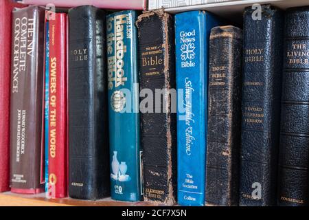 Bibles and other religious and Christian religion books on a bookshelf. Stock Photo