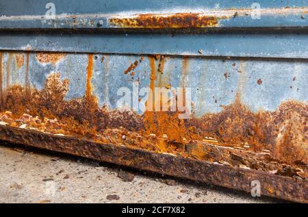 Rusty garage door. Damaged rusting metallic garage door covered in rust (AKA Iron oxide, Iron(III) oxide, Ferric oxide). Stock Photo