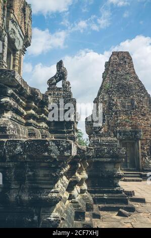 White clouds floating on blue sky over ruined buildings of old oriental temple on sunny day Stock Photo