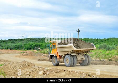 Big mining truck transport of minerals in the quarry. Open-cast mining of extracting rock or minerals from the earth. Largest dolomite deposit open-pi Stock Photo
