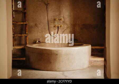 Fragment of interior of bathroom in vintage oriental style with stone bathtub in hotel in Marrakesh city Stock Photo
