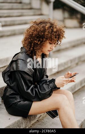 Retro businessWoman using smartphone on stairs Stock Photo