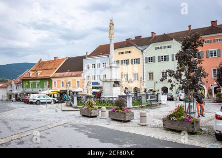 quare with statues in the centre of the town of Murau in state of Steiermark, Austria. Traditional central european buildings in light colors. Stock Photo