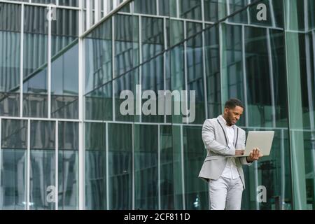 Black man holding laptop on street Stock Photo