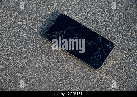Mobile smartphone with a broken screen on the ground. Repair Gadgets Background Stock Photo