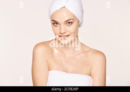 Good-looking Woman with moisturized skin posing in towel on face and body isolated on white background Stock Photo