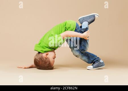 break dance kids. little break dancer showing his skills in dance studio. Hip hop dancer boy performing over studio background Stock Photo