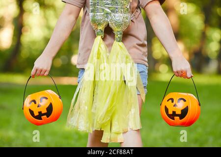 Close-up of girl carrying bags in the form of pumpkins while walking outdoors Stock Photo