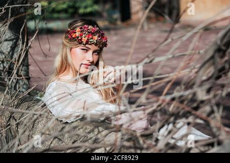 Young bride sitting on bench in garden Stock Photo