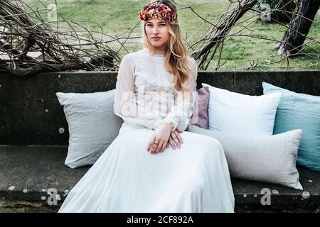 Young bride sitting on bench in garden Stock Photo