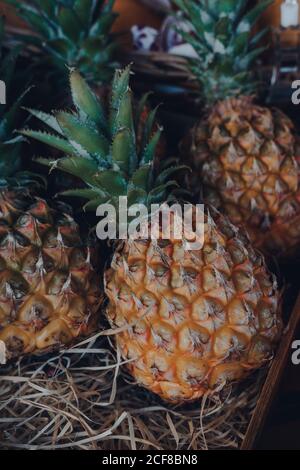 Mini pineapples in a wooden crate on sale at a street market in London, UK. Stock Photo