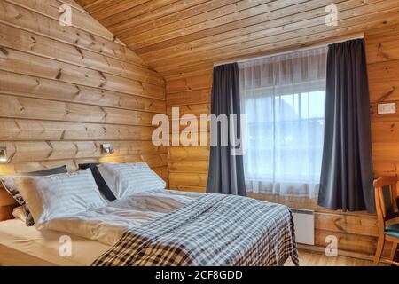 Simple hotel room interior with wooden furniture, television on cabinet ...