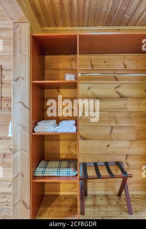 Cupboard shelves with towels and plaid built in wooden wall cupboard near Stock Photo