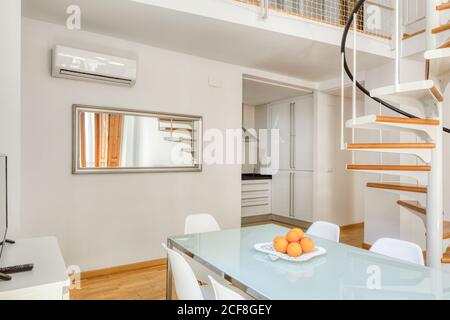 Interior stylish dining room and stairs in large modern duplex apartment in daylight Stock Photo