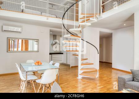 Interior stylish dining room and stairs in large modern duplex apartment in daylight Stock Photo