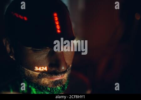 Young man with letters ad Focus word on his face in the dark. Stock Photo