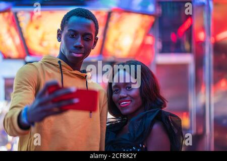 Black couple taking selfie on fairground Stock Photo