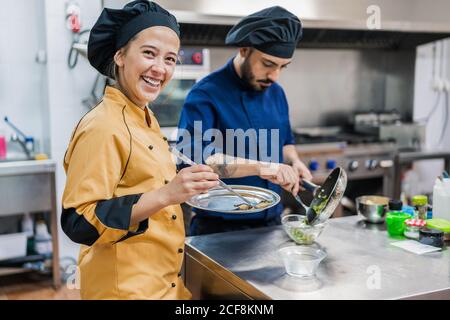 Professional chefs preparing dish in restaurant kitchen Stock Photo