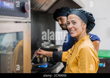 Professional chef and assistant working in kitchen Stock Photo