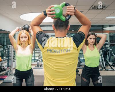 Weightlifting group, kettlebell squat and fitness, exercise class in gym  for muscle training and bodybuilding. people Strong, man and women workout  Stock Photo - Alamy