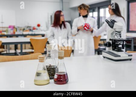Test tubes near teacher and students in lab Stock Photo