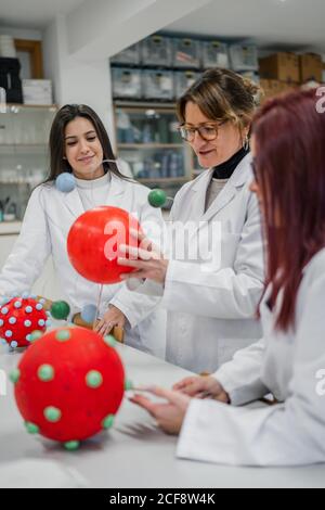 Female scientist and students examining molecule models in lab Stock Photo