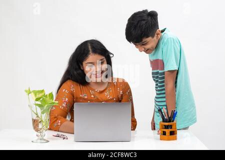A boy looks at the laptop as the girl sits on a table, distance learning for students, study from home, online education, Discussing project. Stock Photo