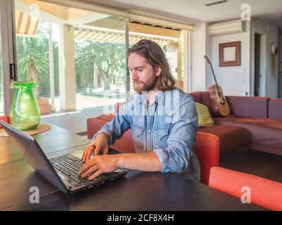 Focused man using computer in apartment Stock Photo