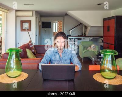 Focused man using computer in apartment Stock Photo