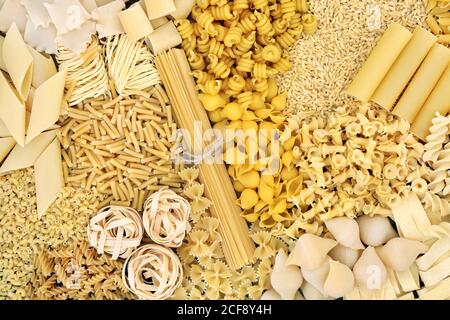Large dried Italian pasta food collection forming an abstract background. Healthy diet concept. Flat lay. Stock Photo