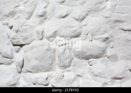 Textured bleached stone wall, painted rough stones texture, monastery wall, abstract background Stock Photo