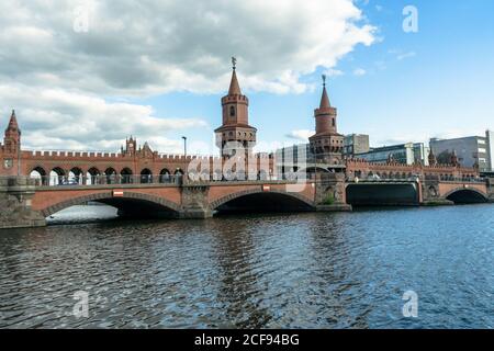 BERLIN, GERMANY - May 14, 2020: BERLIN, GERMANY May 14, 2020. The Oberbaum Bridge on the Spree with a blue sky and clouds. It connects Friedrichshain Stock Photo