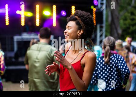 Pretty girl with afro hair dancing at We Are Not a Festival socially distanced event in Pippingford Park - camping with a festival vibe Stock Photo