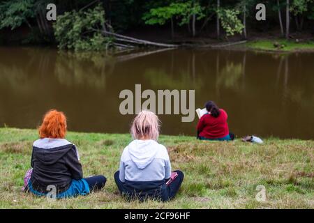 Chilling and reading a book by the lake at We Are Not a Festival socially distanced event in Pippingford Park - camping with a festival vibe Stock Photo