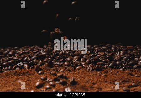 Falling fresh roasted coffee beans and powder coffee isolated on black background Stock Photo