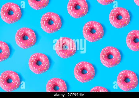 Seamless pattern from pink sweet doughnuts placed on blue background Stock Photo