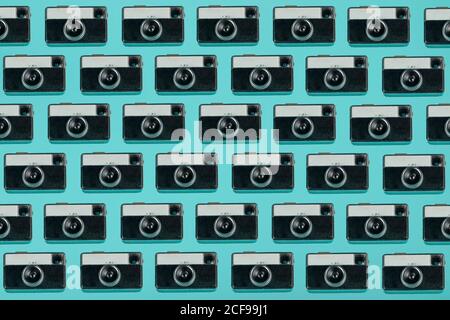 Seamless pattern composed of overhead vintage photo cameras arranged on blue background Stock Photo