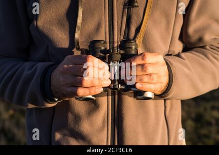 Cropped unrecognizable man looking through an old binoculars the fauna of a lagoon in Spain Stock Photo