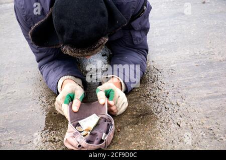 Homeless beggar asks for alms on the bridge.Beggar begging on the street.A homeless man on a city street. A homeless person. Stock Photo