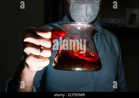 anonymous male barista wearing protective mask during covid 19 pandemic standing in coffee shop with chemex coffeemaker Stock Photo