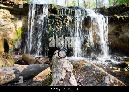 Retro alarm clock on waterfall background. Abstract photo of time. Stock Photo