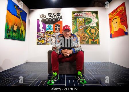Fashion and portrait photographer David Bailey sits in front of four of his 50 unseen oil paintings that form part of his new exhibition which opens on September 7 at the W1 Curates Gallery, at Flannels, Oxford Street, London. Stock Photo
