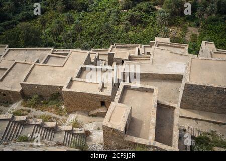 From above of distant roofs of stone aged buildings of ancient Marble Village near green tropical forest in Al Bahah in Saudi Arabia Stock Photo