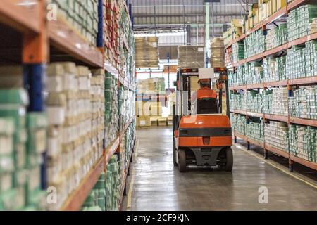 Man worker with forklift in storage warehouse