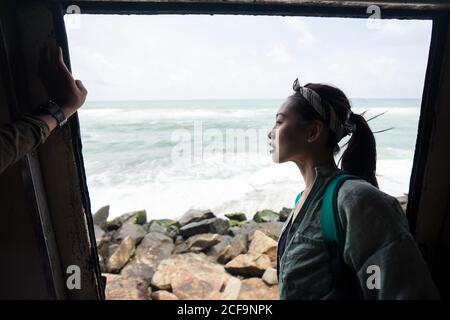 Curious female on vacation travelling by coastal train Stock Photo