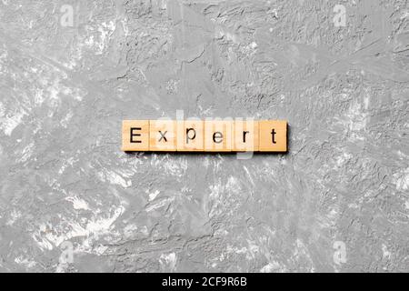 expert word written on wood block. expert text on table, concept.